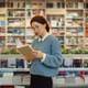 Young woman reading a book in a colorful bookstore - PhotoDune Item for Sale