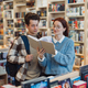 Young couple browsing books in a modern library - PhotoDune Item for Sale