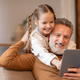 Man and Little Girl Sitting on Couch Viewing Tablet - PhotoDune Item for Sale