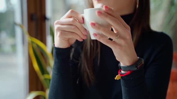 Beautiful girl drinking coffee in a cafe alt
