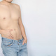 Man displaying his torso with blue jeans, white background,Sexuality, masculinity, intimate areas. - PhotoDune Item for Sale