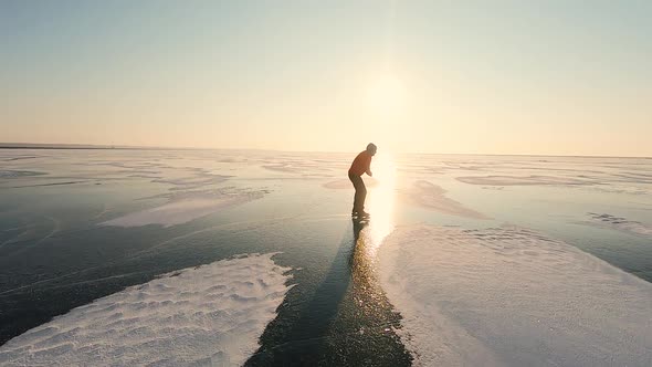 Ice Skating on Frozen Lake at Sunrise alt