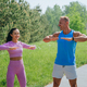Fit man and woman exercising outdoors, practicing stretching in a sunny park setting - PhotoDune Item for Sale