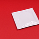 unopened white condom packet on red background with copy space - PhotoDune Item for Sale