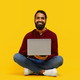 Man Sitting on Floor With Laptop Against Yellow Background - PhotoDune Item for Sale