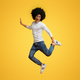 Happy black guy jumping on orange studio background - PhotoDune Item for Sale