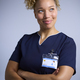 Studio Portrait Of Smiling Female Nurse Wearing Uniform With Digital Tablet Against Grey Background - PhotoDune Item for Sale