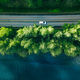 Aerial view of road between green tree forest and blue lake sea water in Finland - PhotoDune Item for Sale