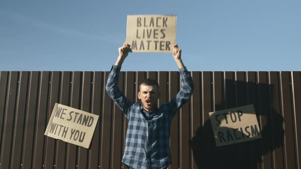 Man waving "black lives matter" sign during rally about the plurality of violence & police brutality alt