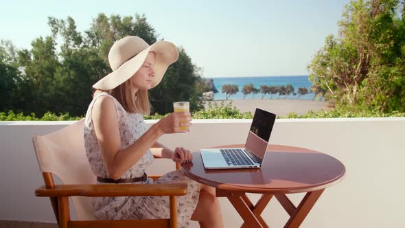 Woman Calls and Talks Online on Laptop on Vacation at Hotel with Sea View