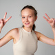 Young Girl Making a Peace Sign on gray background - PhotoDune Item for Sale
