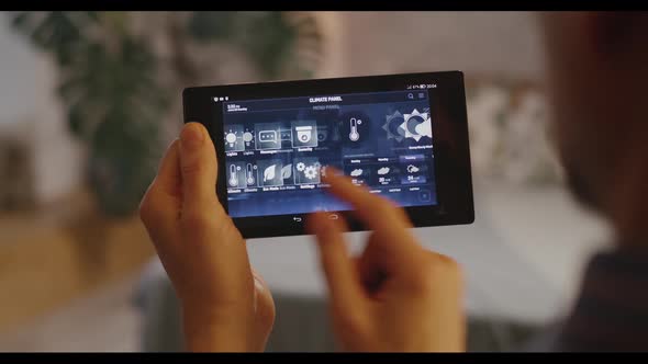 Man Checking Various Functions on Home Hub alt