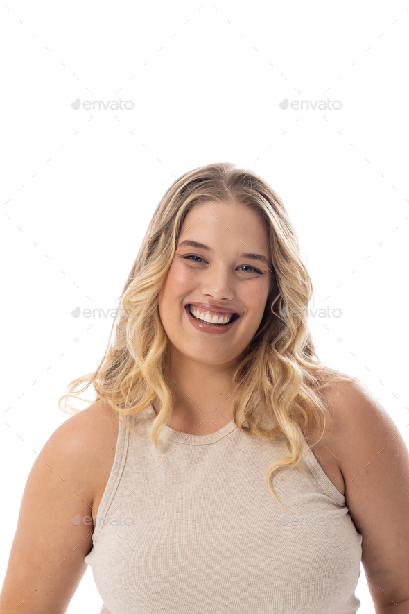 Smiling Caucasian plus size model in sleeveless top on white, copy ...