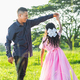 father holding his daughter by the hand to give her a twirl on her own while looking at her proudly - PhotoDune Item for Sale