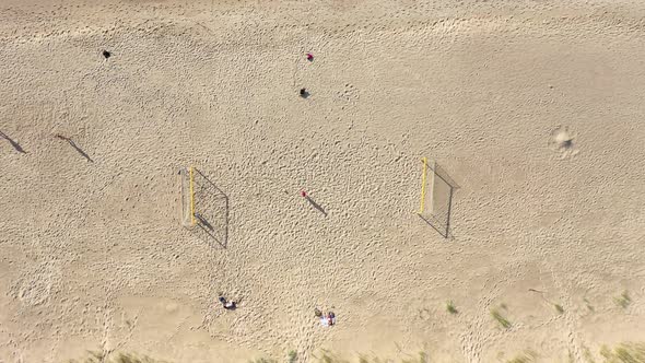 AERIAL: Symmetrical Descend Shot of Football Court on a Sandy Beach on Sunny Day