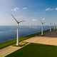 A line of wind turbines gracefully turning in the breeze beside a vast expanse of water, creating a - PhotoDune Item for Sale