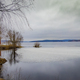 Vast lake bordered by lush greenery and trees under cloudy skies in Ludvika town, Sweden - PhotoDune Item for Sale