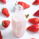 Glass bottle filled with strawberry-flavored milk surrounded by fresh strawberries - PhotoDune Item for Sale