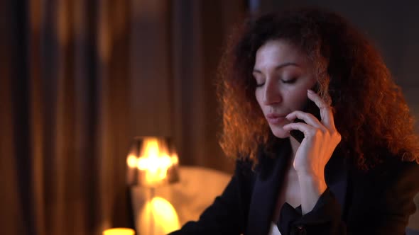 Close Up of Attractive Curlyhaired Business Woman is Conducts Work Negotiations on the Phone While alt
