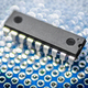 DIP package integrated circuit microchip on a blue printed circuit protoboard or breadboard. - PhotoDune Item for Sale
