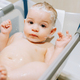 Portrait of a nine month old baby taking a bath in a baby bathtub - PhotoDune Item for Sale