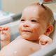 Portrait of a nine month old baby taking a bath with water running trough his face - PhotoDune Item for Sale