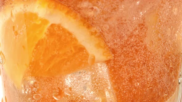 Pouring Mineral Carbonated Water Glass with Natural Orange Pieces Slow Motion Closeup Macro Shot alt