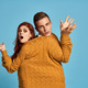 couple in yellow sweater posing against blue background cropped view - PhotoDune Item for Sale