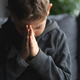 Young Boy Sitting on a Sofa With Hands Clasped in a Moment of praying - PhotoDune Item for Sale