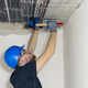 Electrician installing laying electrical cables on the ceiling inside the house. - PhotoDune Item for Sale