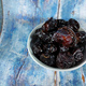 Selective focus.Dried sweet dates on bowl on blue wooden table background. - PhotoDune Item for Sale