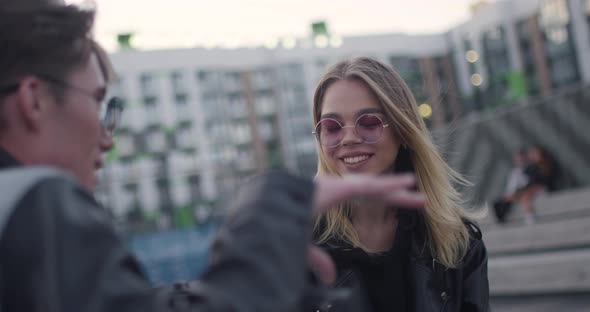 Young People Communicate, Boy and Girl Talks Near a Modern Residential Area, Evening in the City alt