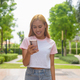Portrait of beautiful Asian girl with blonde hair smiling using phone outdoors - PhotoDune Item for Sale