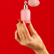 Unrecognizable woman hand holding perfume bottle on red backdrop - PhotoDune Item for Sale