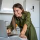 Pleased woman with smile using laptop for online distant communication internet in home kitchen. - PhotoDune Item for Sale
