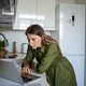 Focused on screen laptop woman standing on home kitchen attentive search information in internet web - PhotoDune Item for Sale