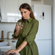 Focused woman standing on home kitchen with laptop, drinking water to calm down after working day. - PhotoDune Item for Sale