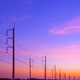 Silhouette 2 rows of electric poles with cable lines on country road against colorful sunset sky - PhotoDune Item for Sale