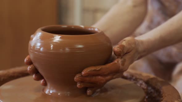 Elderly Hands of a Potter Creating an Earthen Jar on the Circle alt