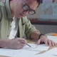Close Up Of Asian Man Designer Sketching Hand Bag On The Layout Bond At The Office - VideoHive Item for Sale