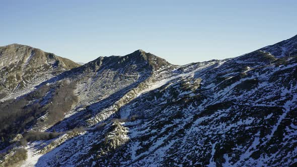 Aerial, Alps mountains partially covered with snow in Italy