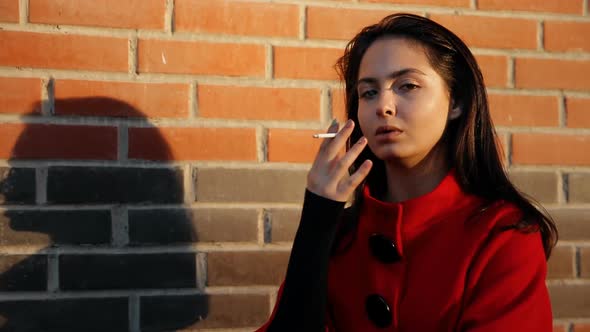 A Young Woman Smokes a Cigarette