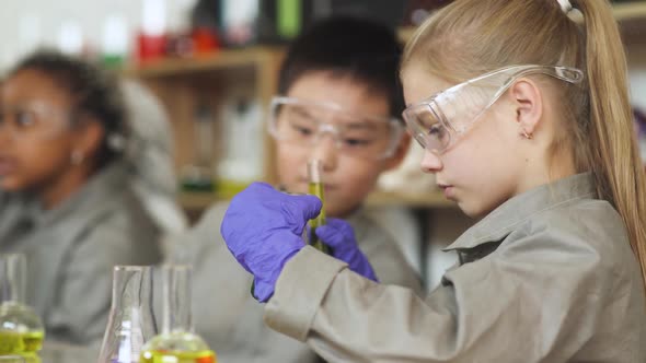 Laboratory Experience in a Chemistry Lesson Girl and Asian Boy in Protective Glasses Holding a alt