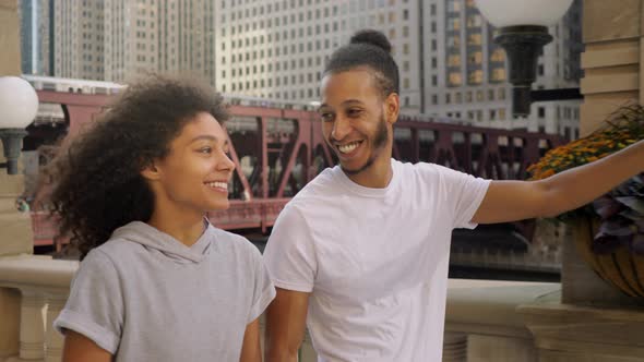 Cute African American couple walking along the Chicago River alt