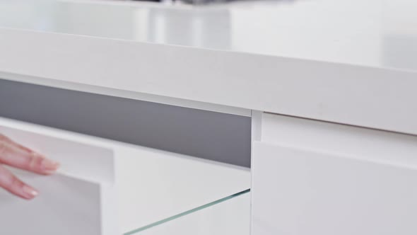 Close up of a white modern luxury kitchen drawer closing slowly alt