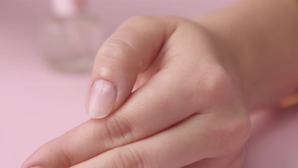 Woman Hand on Pink Makes Manicure for Herself