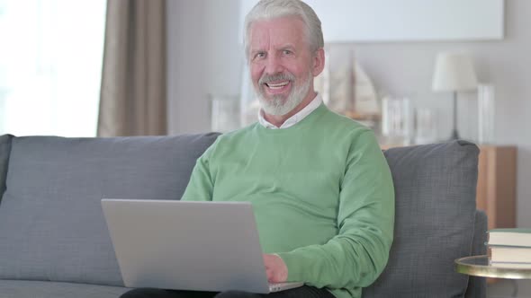 Old Man with Laptop Smiling at the Camera alt