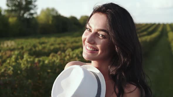 Close Portrait of Amazing Girl Smiling Lightly at Camera Among Bush Plantation alt