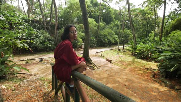 Girl sitting on a wood bridge orange leaves background alt