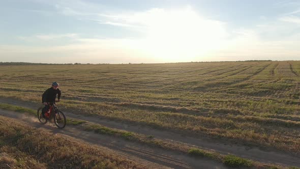 Biker in Green Helmet Rides Mtb Electro Full Suspension Mountain Bicycle E-bike Along Rural Dirty alt